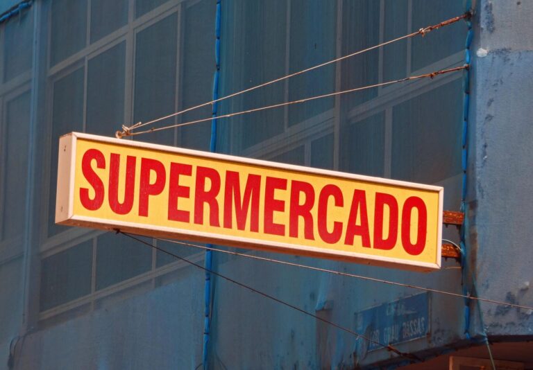 Close-up of a vibrant supermercado sign hanging outdoors in Las Palmas, Spain.